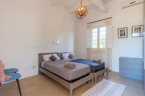 a bedroom with a bed and a blue chair at POOL & SPA - wellness VILLA St Martin in Mġarr