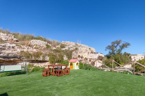 a field with a picnic table and a gazebo at POOL & SPA - wellness VILLA St Martin in Mġarr