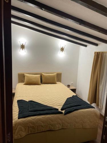 een slaapkamer met een bed met twee lampjes aan de muur bij Villa Elias in Zlatograd