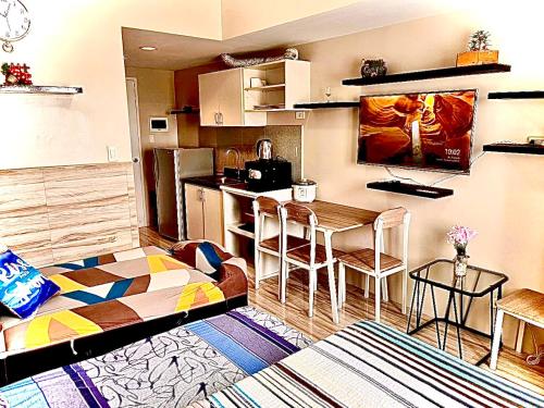 een kleine kamer met een keuken en een bed bij Across Sm City Cebu Sunvida Tower Studio Unit in Cebu City