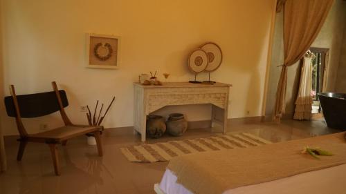 a room with a fireplace and a chair and a mirror at Chakra Living Ubud in Ubud