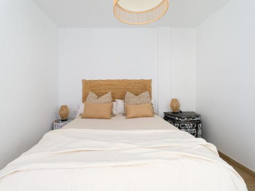 sypialnia z łóżkiem z białą pościelą i poduszkami w obiekcie Arena y Calma Jandia con aire acondicionado w mieście Morro del Jable
