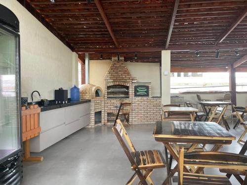 cocina con mesa, sillas y horno de ladrillo en Flat 705 Villa Hipica Gravata PE, en Gravatá