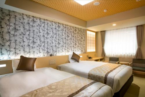 大阪的住宿－Hot Spring from Deep Water Osaka Hinode Hotel Nipponbashi，酒店客房设有两张床和窗户。