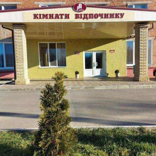a small tree in front of a yellow building at Hotel Elegia in Trostyanets