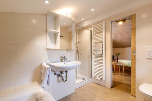 ein weißes Bad mit einem Waschbecken und einem WC in der Unterkunft Haus Huis'n in Grainau