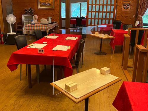 un restaurante con mesas rojas y sillas en una habitación en Tsubame Highland Lodge燕ハイランドロッジ, en Myoko