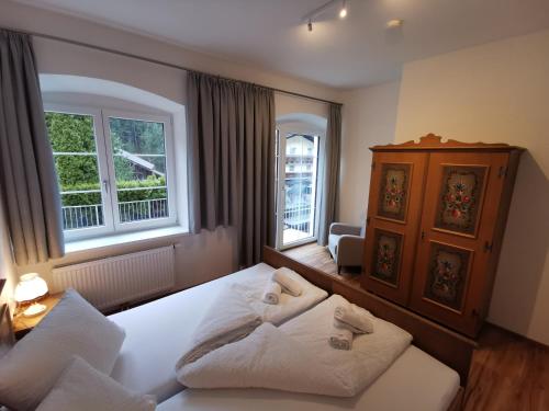 sypialnia z dużym białym łóżkiem i dwoma oknami w obiekcie Apartments HAUS SCHÖN - Preise inclusive Pitztal Sommer Card w mieście Jerzens