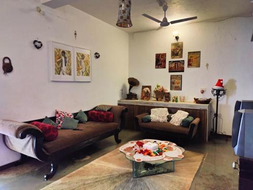 a living room with two couches and a table at Aqua Arina Holiday Farm House in Murud