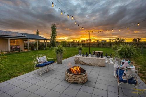 a patio with a fire pit and a table and chairs at 'Vineyard Cottage' A Golden Escape among the Vines in Mudgee