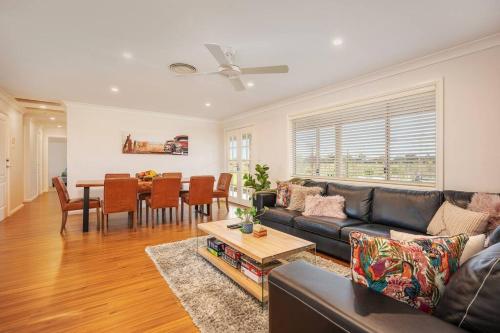 a living room with a couch and a table at 'Vineyard Cottage' A Golden Escape among the Vines in Mudgee