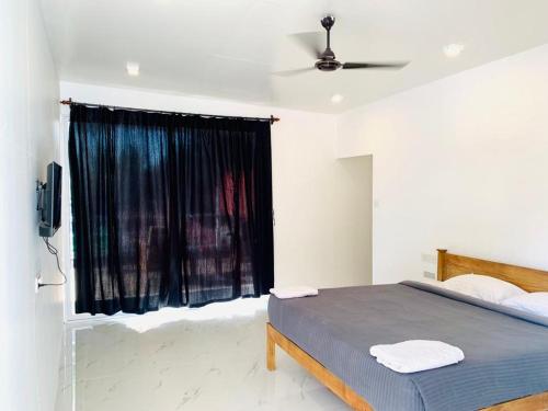 a bedroom with a bed and a black window at Crystall Goa, Onyx Edition in Palolem