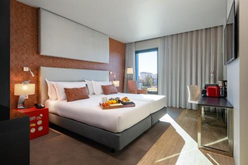 a hotel room with a bed with a tray of fruit on it at Meliá Lisboa Aeroporto in Lisbon