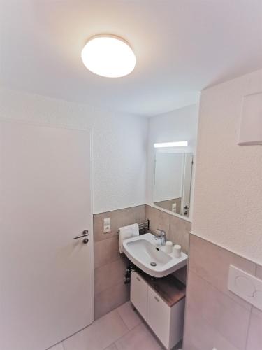 a white bathroom with a sink and a mirror at Apartments HAUS SCHÖN - Preise inclusive Pitztal Sommer Card in Jerzens