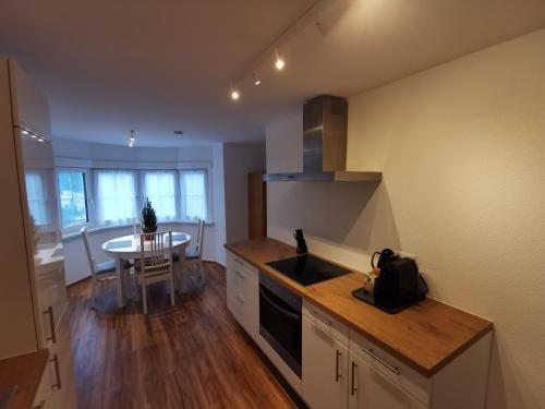 a kitchen with a sink and a table in it at Apartments HAUS SCHÖN - Preise inclusive Pitztal Sommer Card in Jerzens