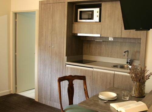 a kitchen with a table and a microwave at Hôtel Albion in Ajaccio