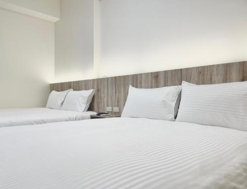 Duas camas num quarto com lençóis e almofadas brancos em Between mountains B&B em Jian