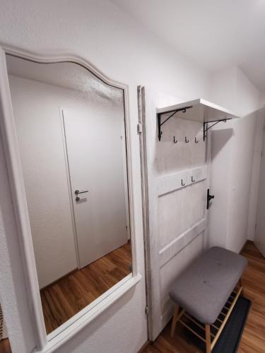 a room with a mirror and a chair and a door at Apartments HAUS SCHÖN - Preise inclusive Pitztal Sommer Card in Jerzens