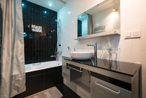 La salle de bains est pourvue d'un lavabo et d'un miroir. dans l'établissement Nadezhda Apartment on Nauryzbay batyr 37, à Almaty