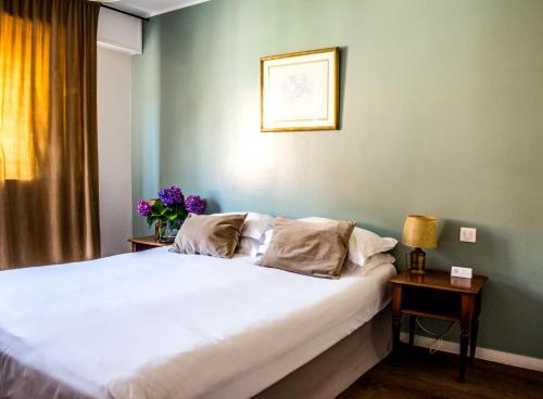 a bedroom with a large white bed in a room at Hôtel Albion in Ajaccio