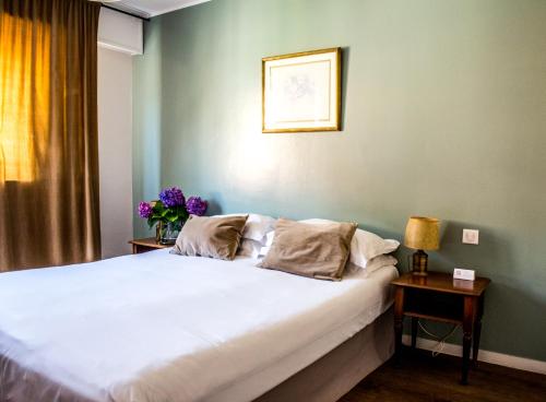 una camera con un grande letto bianco di Hôtel Albion ad Ajaccio