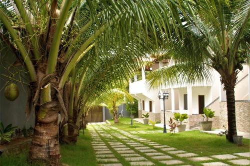 una palmera en el patio de una casa en Residencial Jardim Imbassai 4 apt mobiliado com piscina, en Mata de Sao Joao