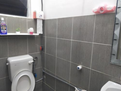a bathroom with a toilet and a sink at Taman Tunku Miri Budget Homestay in Miri