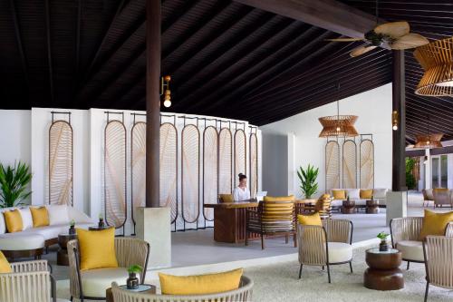 a rendering of a lobby with yellow pillows and chairs at Anantara Veli Maldives Resort in South Male Atoll