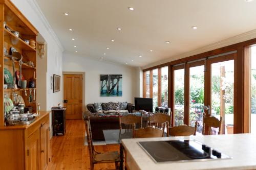 una cucina e un soggiorno con tavolo e sedie di North Adelaide Heritage Cottages & Apartments a Adelaide