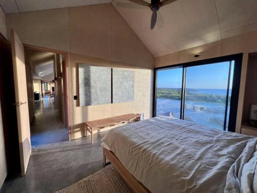 a bedroom with a large bed and a large window at Native Dog Cabin in Bremer Bay