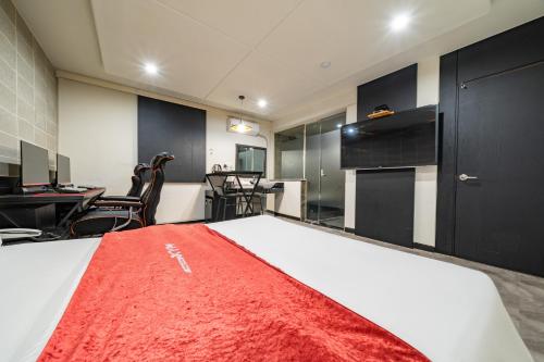 a room with a bed with a red blanket on it at Boutique Hotel XYM in Suwon