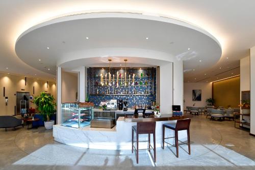 a lobby with a bar with a table and chairs at Clarion Hotel Jeddah Airport in Jeddah
