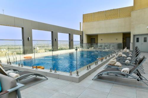 ジッダにあるClarion Hotel Jeddah Airportの大型スイミングプール(ラウンジチェア付)