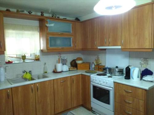 cocina con armarios de madera y horno de fogón blanco en TRADITIONAL HOUSE, en Monemvasia