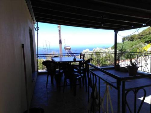 een tafel en stoelen op een balkon met uitzicht op de oceaan bij TRADITIONAL HOUSE in Monemvasia