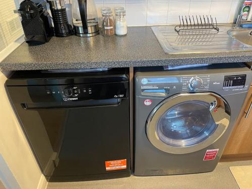 ロンドンにあるSelf-catering fully equipped apartment in Vauxhallのカウンター横のキッチンに洗濯乾燥機
