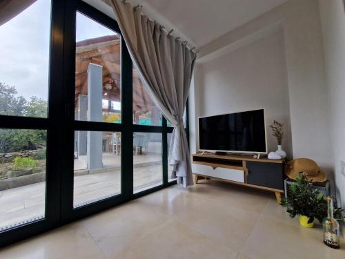 a living room with a tv and a large window at Lavanda apartman 1 in Cres