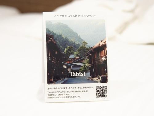 a poster of a village with a mountain in the background at Tabist Ginza in Tokyo