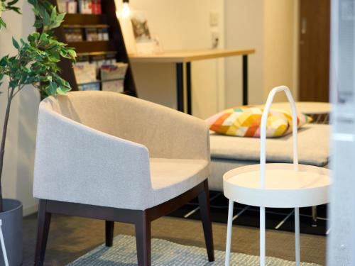 a couple of chairs and a table and a bed at Tabist Ginza in Tokyo