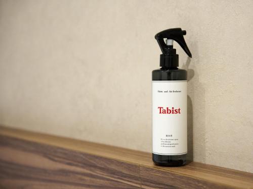 a black and white spray bottle sitting on a shelf at Tabist Ginza in Tokyo