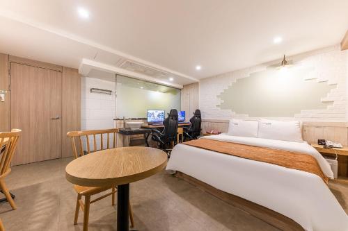 a room with two beds and a desk with a computer at Boutique Hotel XYM in Suwon