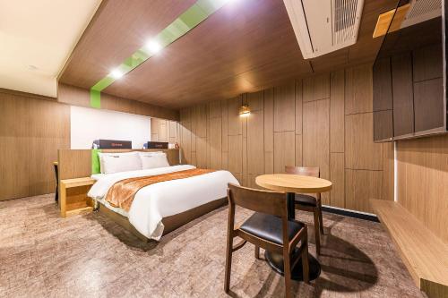 a hotel room with a bed and a table at Boutique Hotel XYM in Suwon