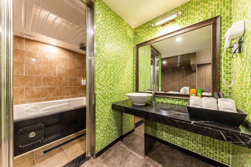 ein Bad mit einem Waschbecken und einem Spiegel in der Unterkunft Boutique Hotel XYM in Suwon