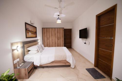 a bedroom with a white bed and a television at Lotus & Orchid Villas by Ramnath Homes in Sangolda