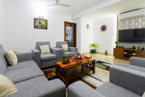 a living room with couches and a tv at Lotus & Orchid Villas by Ramnath Homes in Sangolda