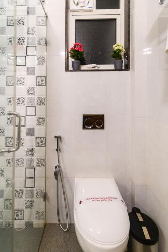 a bathroom with a toilet and a window and a shower at Lotus & Orchid Villas by Ramnath Homes in Sangolda