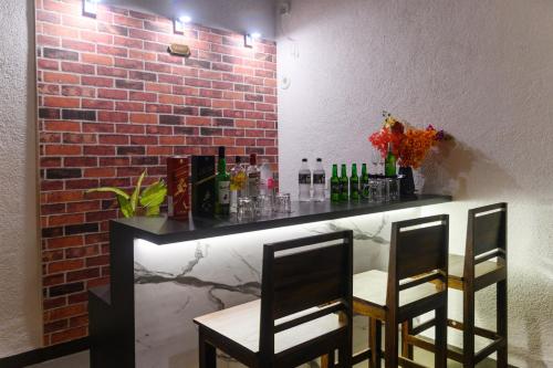 a bar with two chairs and a brick wall at Lotus & Orchid Villas by Ramnath Homes in Sangolda