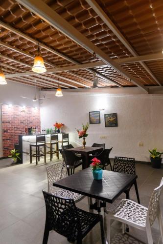 a restaurant with tables and chairs and a counter at Lotus & Orchid Villas by Ramnath Homes in Sangolda
