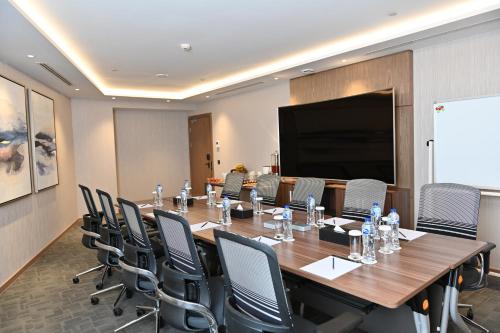 a conference room with a long table and chairs at Clarion Hotel Jeddah Airport in Jeddah