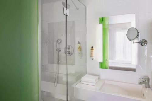 uma casa de banho com um chuveiro e uma porta de vidro em Mercure Paris Gare du Nord em Paris